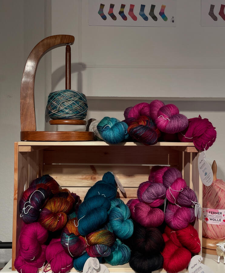 Ein Garnabwickler und verschieden bunten Wollstränge.